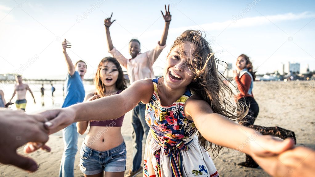 Friends having fun and dancing on beach