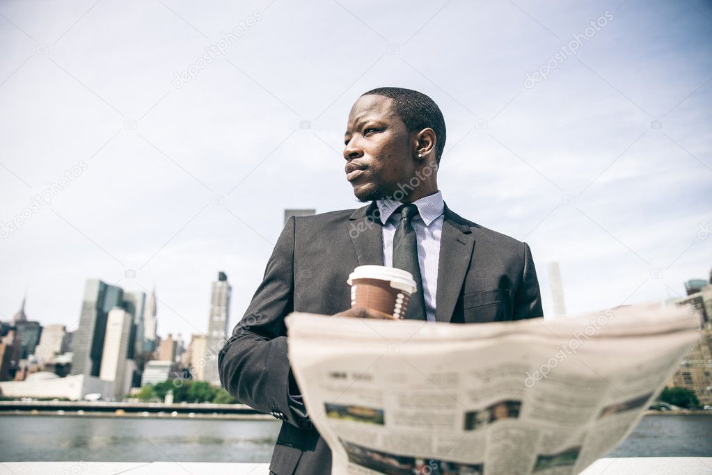 Confident businessman reading newspaper