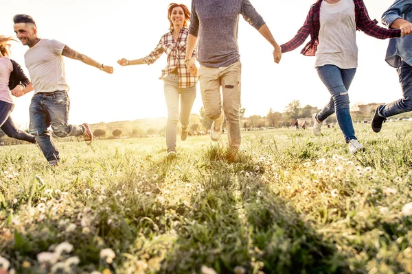 Freunde laufen glücklich im Gras — Stockfoto