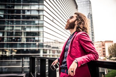 Kırmızı resmi kıyafetli sakallı adam