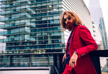 Kırmızı resmi kıyafetli sakallı adam