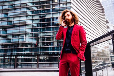 Kırmızı resmi kıyafetli sakallı adam