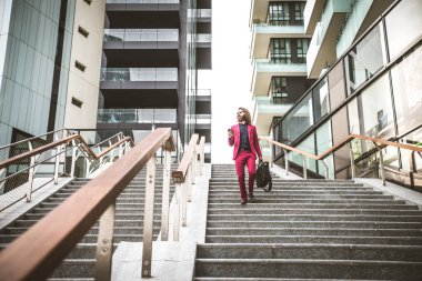 Kırmızı resmi elbiseli yürüyen adam