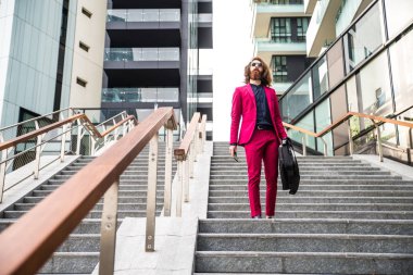 Kırmızı resmi elbiseli yürüyen adam