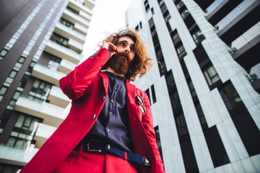 Kırmızı elbiseli yürüyen hipster adam 