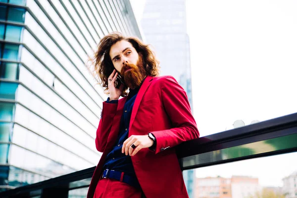 Kırmızı resmi kıyafetli sakallı adam