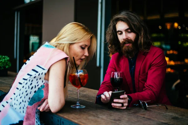 Couple using smartphone in bar