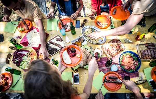 Amigos comendo e bebendo no piquenique — Fotografia de Stock