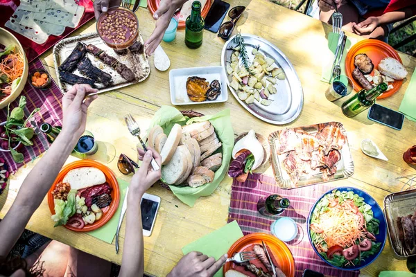 Друзья едят и пьют на пикнике — стоковое фото