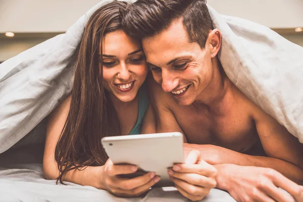 Paar kijken film in bed — Stockfoto