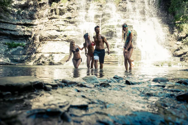 Happy friends near waterfall — Stock Photo, Image