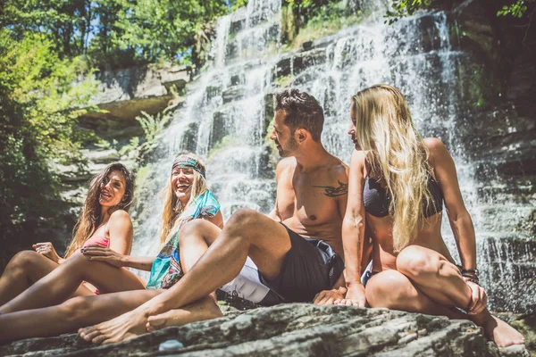 Счастливые друзья у водопада — стоковое фото
