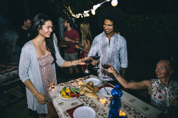 Друзья делают барбекю на заднем дворе
