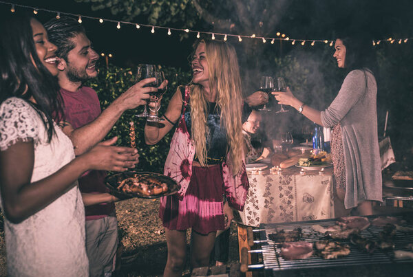 Друзья делают барбекю на заднем дворе
