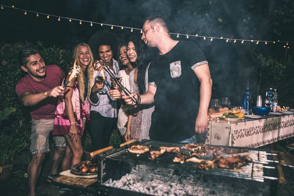 Vrienden maken van barbecue in achtertuin — Stockfoto