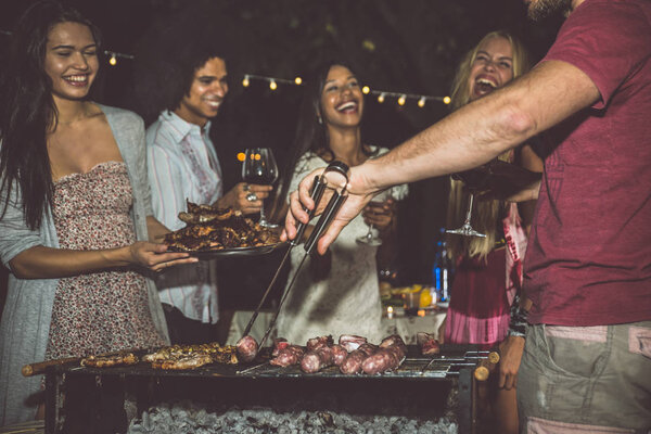 Друзья делают барбекю на заднем дворе
