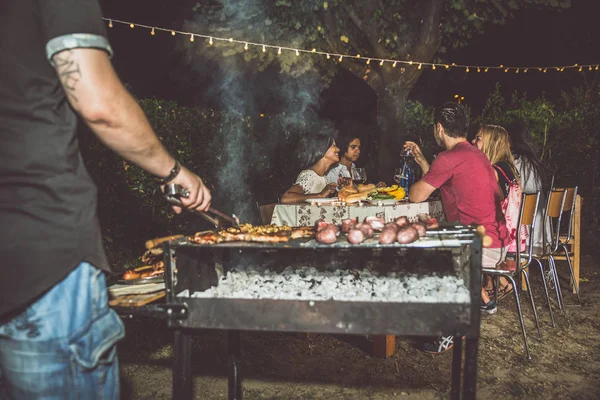 Amici che fanno barbecue in cortile — Foto Stock