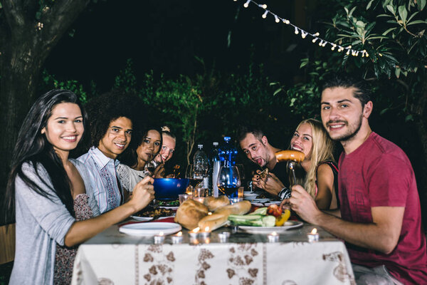 Друзья делают барбекю на заднем дворе
