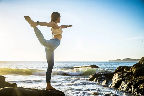 Vrouw praktizerende yoga op het strand — Stockfoto