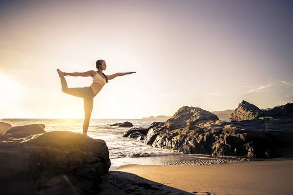 Vrouw praktizerende yoga op het strand — Stockfoto