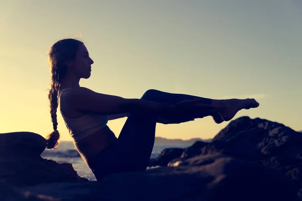 Vrouw praktizerende yoga op het strand — Stockfoto