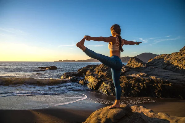 Vrouw praktizerende yoga op het strand — Stockfoto