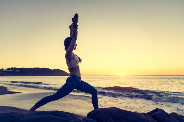 Vrouw praktizerende yoga op het strand — Stockfoto