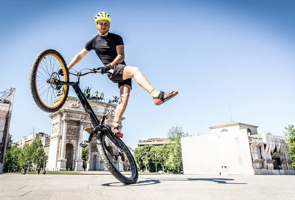 Jovem atleta fazendo truques em sua bicicleta — Fotografia de Stock