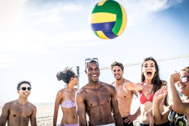 Plaj voleybolu oynarken arkadaşlar 