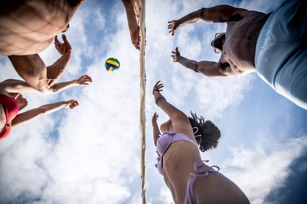 Přáteli, kteří hrají volejbal na pláži — Stock fotografie