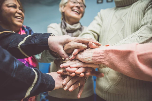 Seniors with hands stacked — Stock Photo, Image