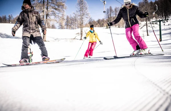 Vänner skidåkning och snowboard — Stockfoto