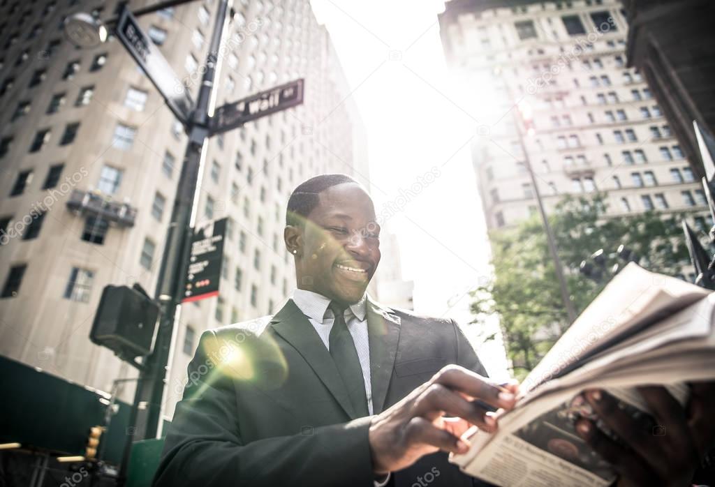 Smiling businessman reading newspaper