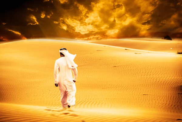 Arabic man with traditional emirates clothes walking in the dese — Stock Photo, Image