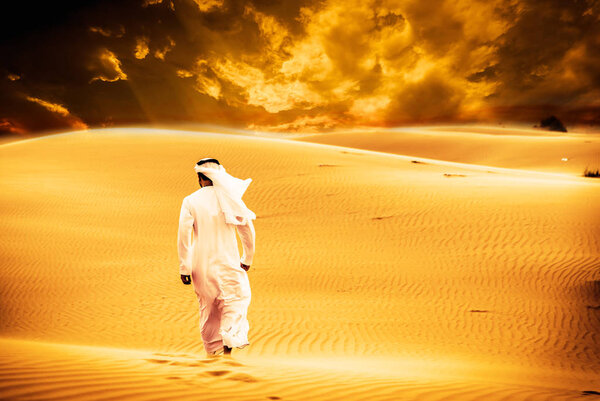 Arabic man with traditional emirates clothes walking in the dese