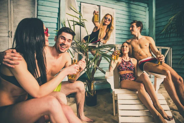 Gruppo di cinque amici che festeggiano nella loro casa al mare estiva — Foto Stock