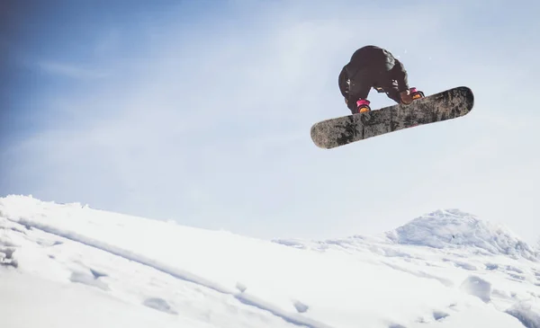 Snoboarder แสดงเทคนิคบนหิมะ ภาพสต็อก
