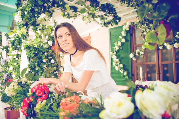 Mujer joven que se aloja frente a su hermosa casa de flores —  Fotos de Stock