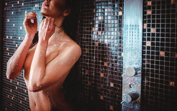 Красивая женщина принимает душ в ванной комнате — стоковое фото