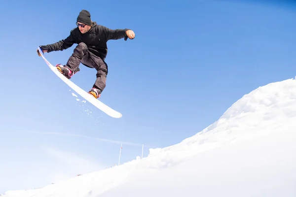 Snowboarder fazendo truques na neve — Fotografia de Stock