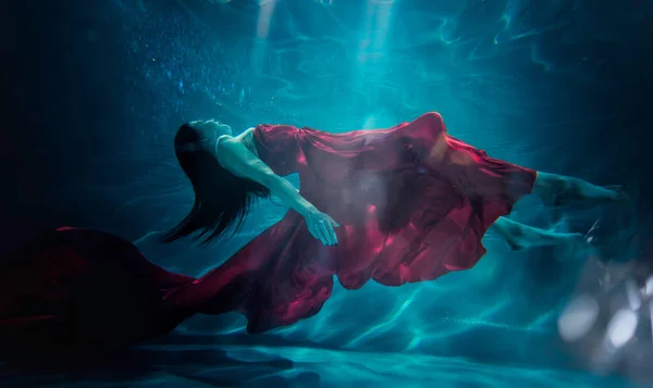 Hermosa mujer nadando con vestido de fantasía bajo el agua — Foto de Stock