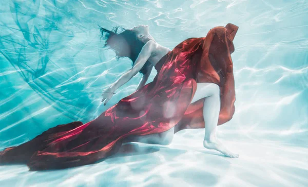 Hermosa mujer nadando con vestido de fantasía bajo el agua — Foto de Stock