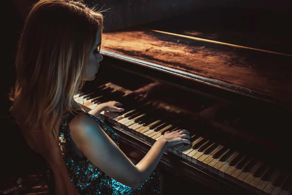 Mulher bonita com vestido elegante fantasia posando no piano roo — Fotografia de Stock