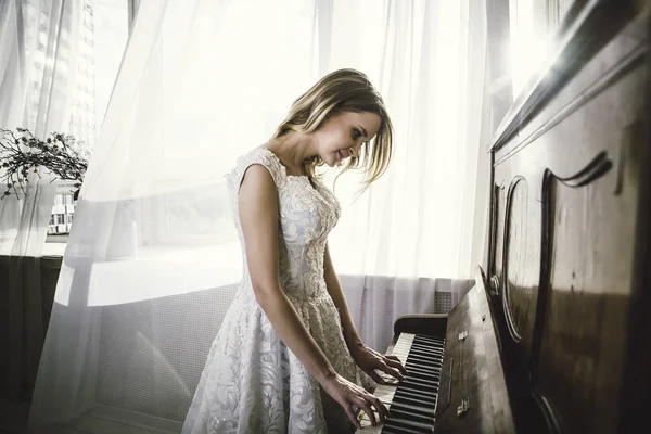 Hermosa mujer con elegante vestido de fantasía posando en el piano roo — Foto de Stock