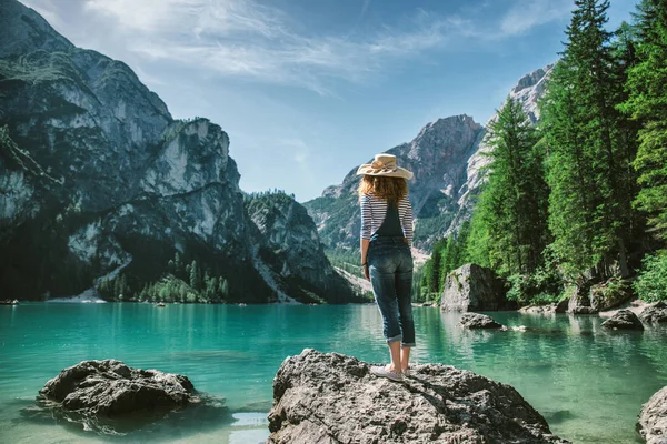 Kadın dağ manzarasına bakıyor. 