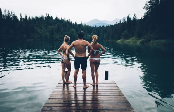 Група друзів веселяться біля озера вранці — стокове фото