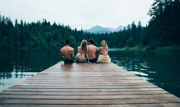 Groep vrienden met plezier aan het meer in de ochtend — Stockfoto