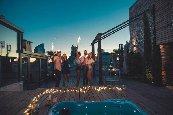 Amigos festejando em um telhado — Fotografia de Stock