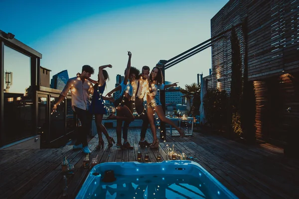 Amigos festejando em um telhado — Fotografia de Stock