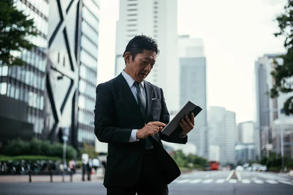 Старший бизнесмен на улицах Токио — стоковое фото